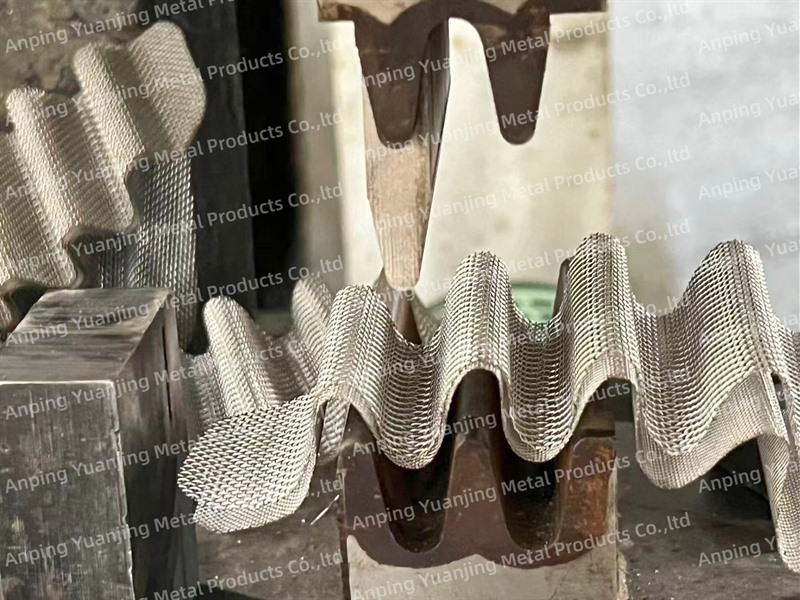 Stainless steel wire mesh being formed into a corrugated filter structure